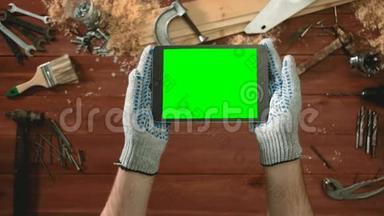 顶景工匠手拿手套，手拿数字平板，水平与绿色屏幕